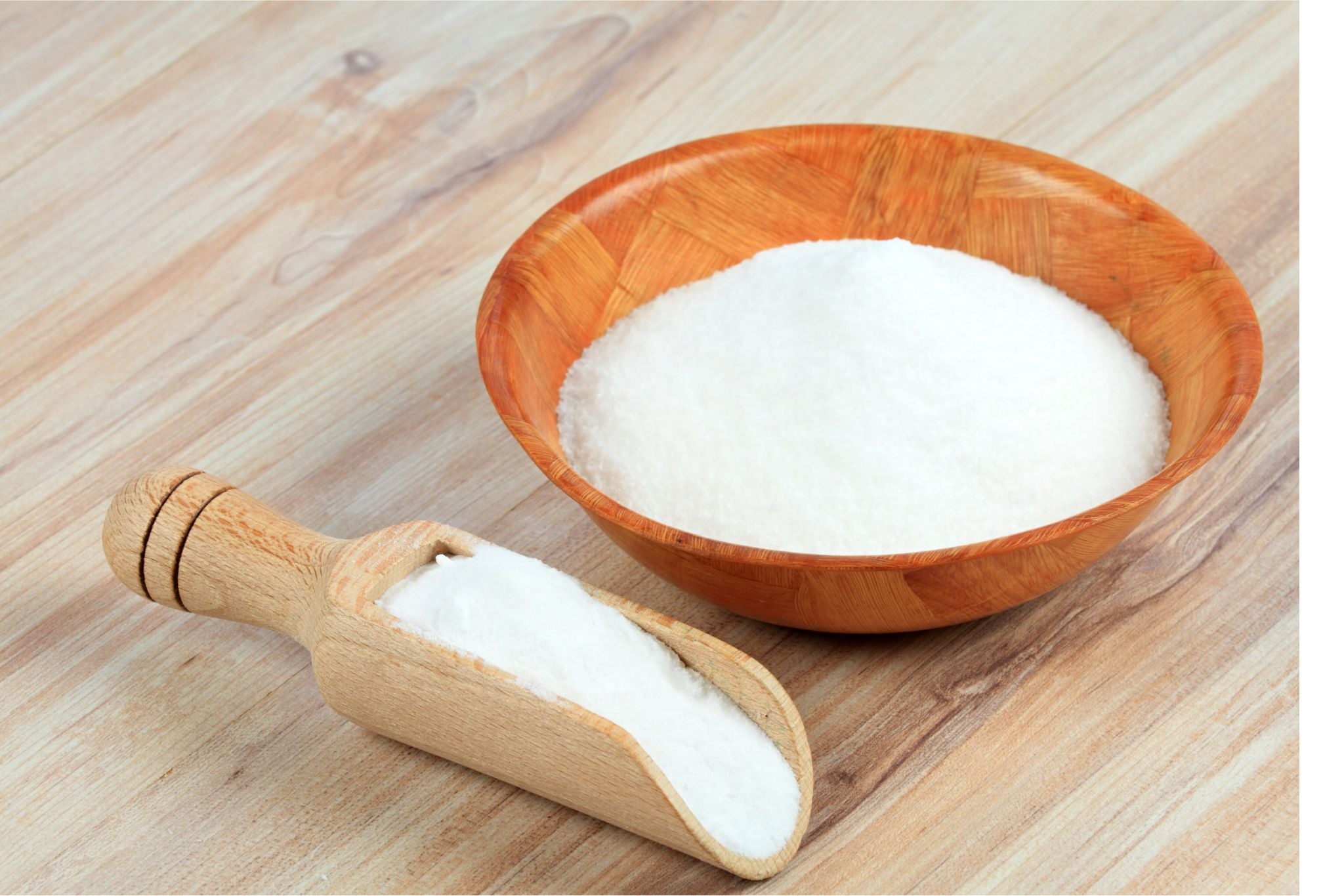 Holzschale und Holzlöffel mit weißem feinem Pulver auf hellem Holztisch