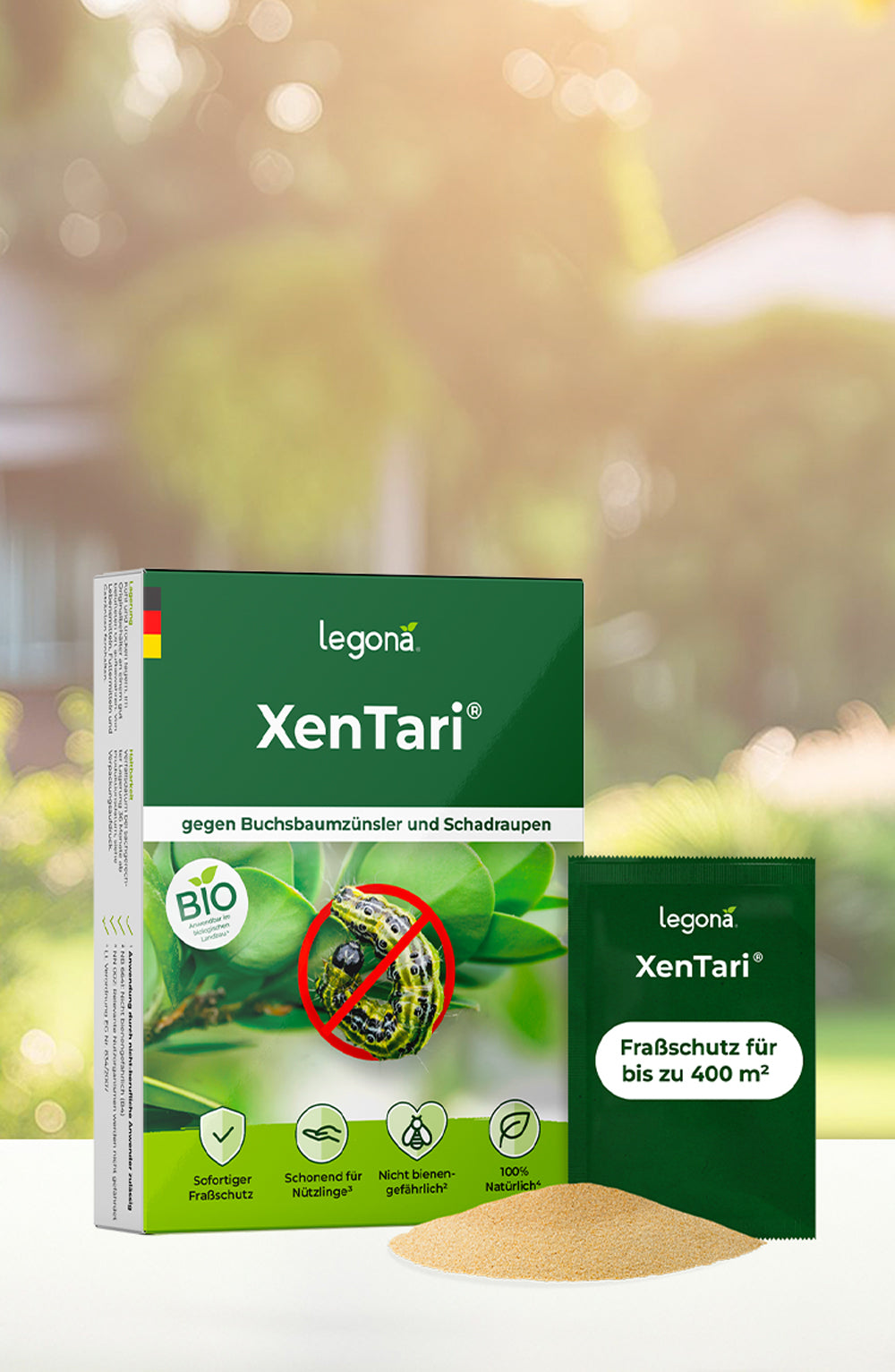 Verpackung von Legona XenTari mit Bild einer Raupe auf einem Blatt, durchgestrichen mit rotem Kreis, daneben ein grünes Pulverhäufchen und ein einzelnes Pulverpäckchen mit der Aufschrift 'Fraßschutz für bis zu 400 m²' vor unscharfem Garten-Hintergrund